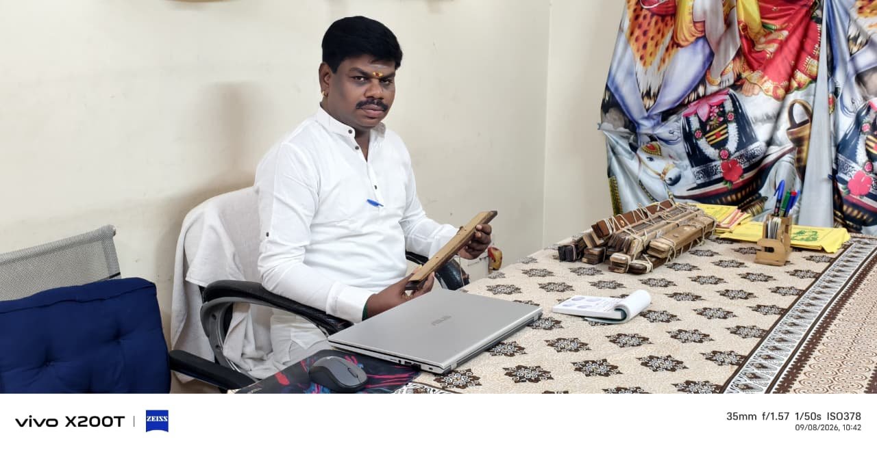 Guruji seated at the reading table with palm leaf bundles